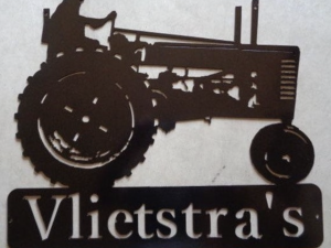 metal tractor sign with farmer on antique tractor