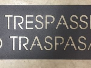 Metal NO TRESPASSING NO TRESPAR sign, spanish no trespassing